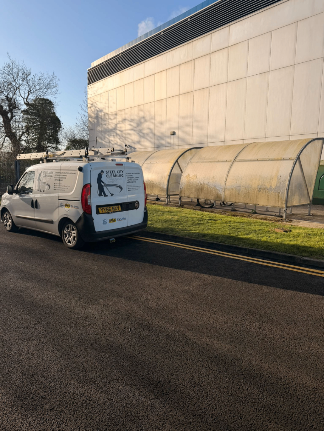 Before cleaning, covered walkway and adjacent cladding with visible yellowing and grime